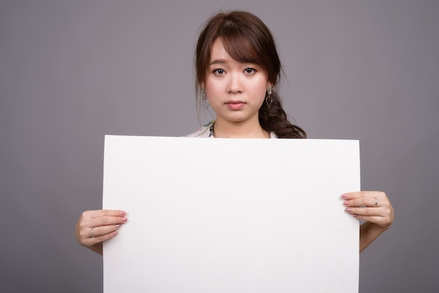 Mujer asiática con tablero blanco vacío con copyspace