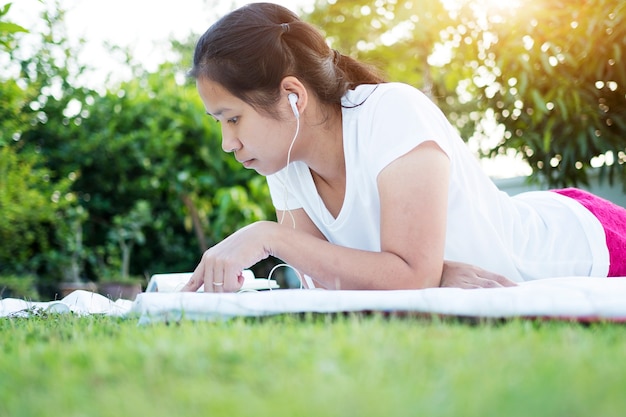 Mujer asiática con tableta digital al aire libre