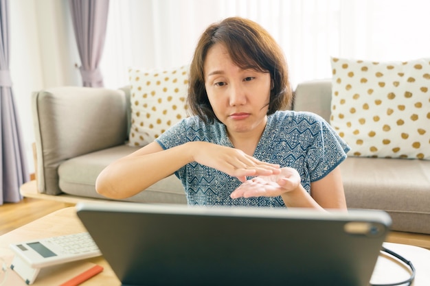 Mujer asiática con tableta, viendo la lección curso en línea de lenguaje de señas