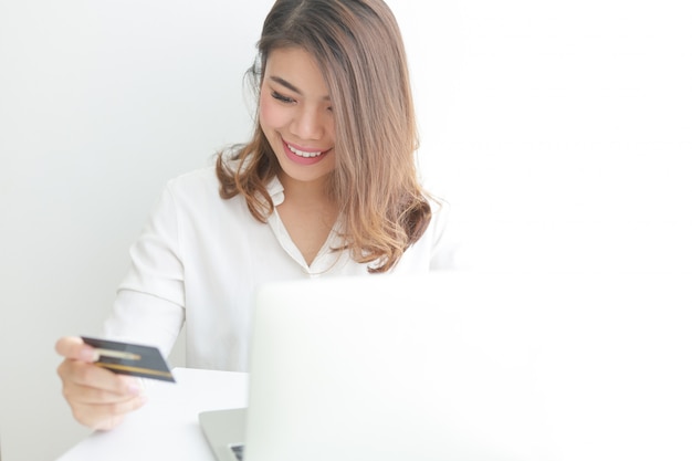 Foto mujer asiática con tarjeta de crédito de compras en línea con computadora portátil