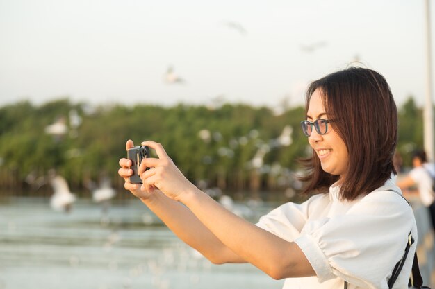 Mujer asiática con un teléfono con cámara.