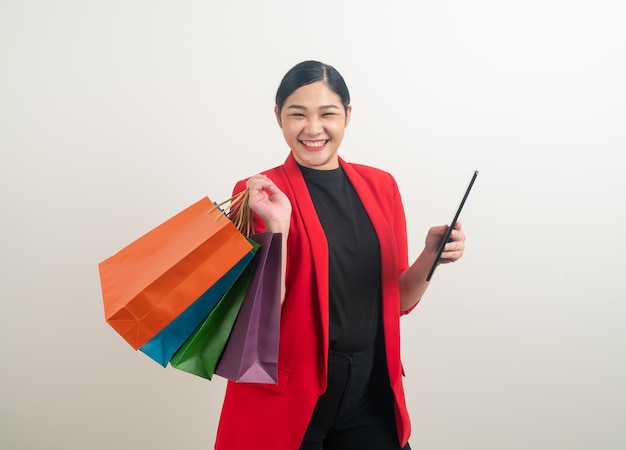 mujer asiática, tenencia, bolsa de compras, y, tableta, en, mano, con, fondo blanco