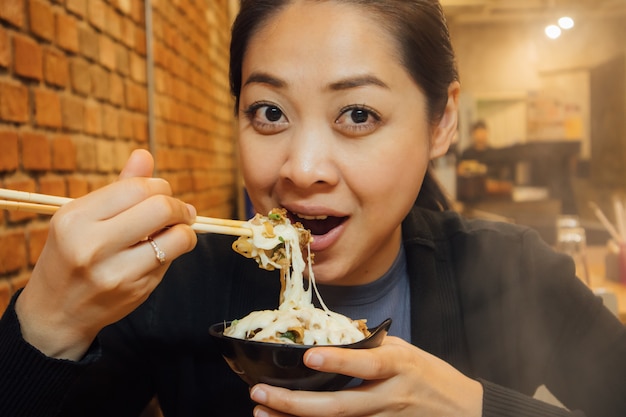 Mujer asiática tiene una cena de estilo shabu para la temporada de invierno.