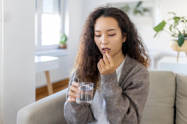 Mujer asiática toma medicamentos con un vaso de agua Norma diaria de vitaminas medicamentos efectivos