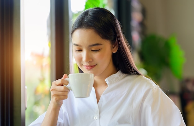 Mujer asiática tomando café en la cafetería