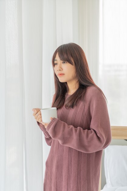 Mujer asiática tomando café en la mañana