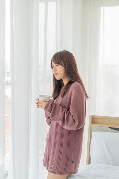 Mujer asiática tomando café en la mañana