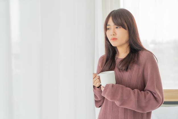 Mujer asiática tomando café en la mañana