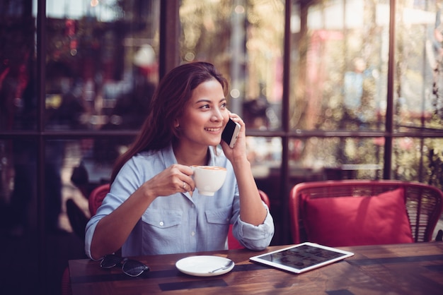 Foto mujer asiática tomando café en tono de color vintage