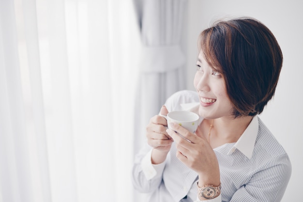 Mujer asiática tomando café