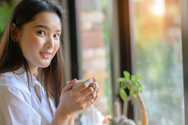 Foto mujer asiática tomando café