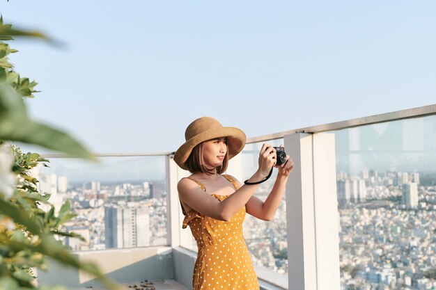 Mujer asiática tomando una foto con cámara profesional