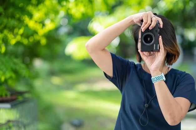 Mujer asiática tomando fotografías fotógrafa profesional