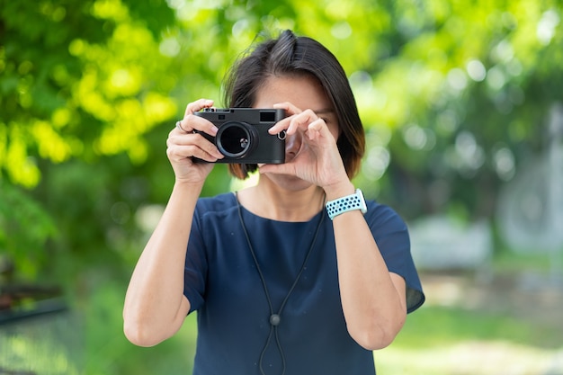 Mujer asiática tomando fotografías, fotógrafo profesional