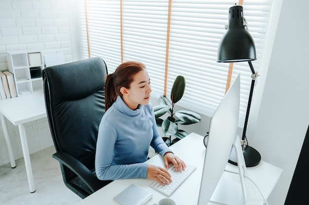 Mujer asiática trabajando desde casa usando la computadora