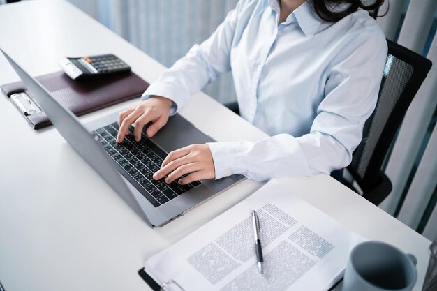 Mujer asiática trabajando usando una computadora portátil Manos escribiendo en el teclado Trabajando en la oficina inversor profesional trabajando en una nueva puesta en marcha