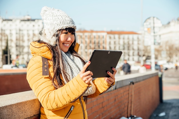 Mujer asiática turística con tableta en la calle europea. Concepto de turismo.