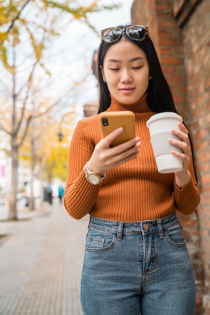 Mujer asiática utilizando su teléfono móvil.