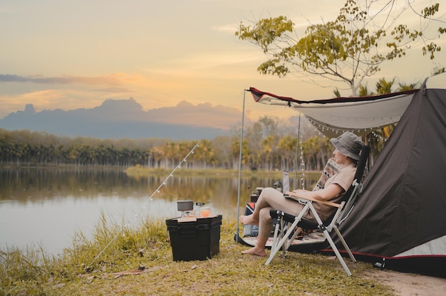 Mujer asiática viaja y acampa sola. Empresaria trabajando en línea y relajándose durante la actividad al aire libre del viaje.