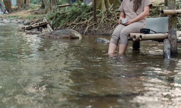 Mujer asiática viaja y acampa sola. Empresaria trabajando en línea y relajándose durante la actividad al aire libre del viaje.