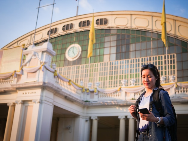 Mujer asiática viajando con teléfono móvil