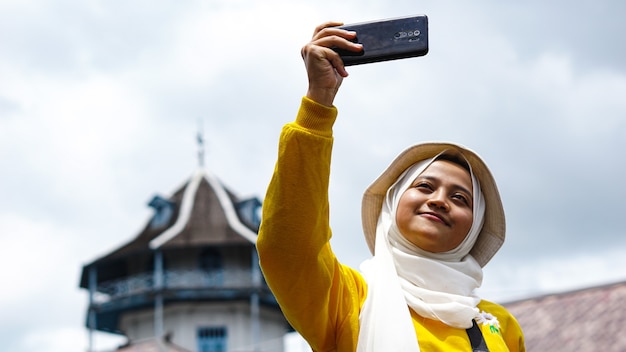 Mujer asiática viajando tomando selfies en el keraton solo