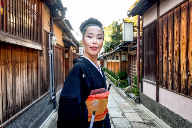 Mujer asiática con yukata caminando en Kyoto, Japón
