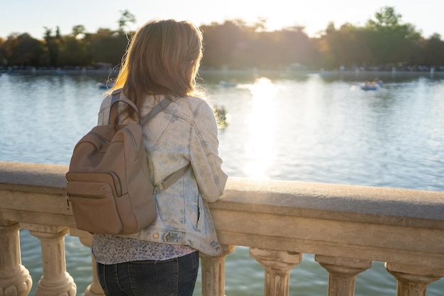 Mujer de asomarse a un gran lago de agua dulce en el Parque del Retiro de Madrid
