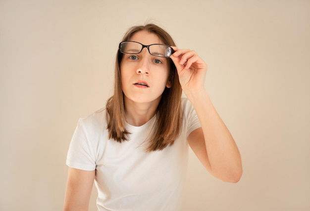 Una mujer asombrada levanta sus gafas mirando incrédulamente a la cámara, intenta ver