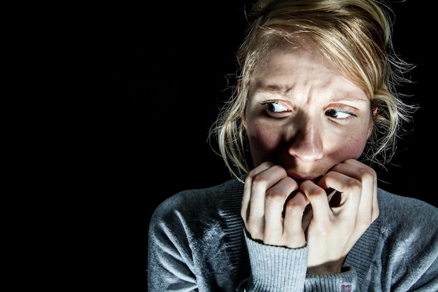 Foto mujer asustada de algo en la oscuridad