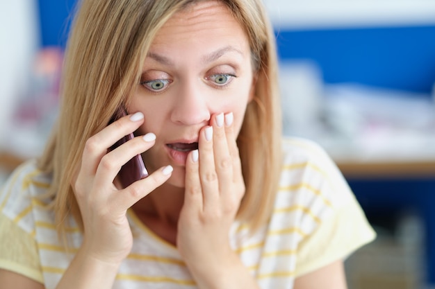 Mujer asustada hablando por teléfono celular conversación emocional en concepto de teléfono inteligente