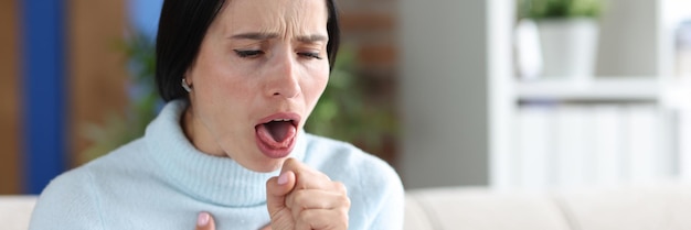 Mujer con ataques de tos se sienta en el sofá signos y síntomas de asma en el concepto de adultos