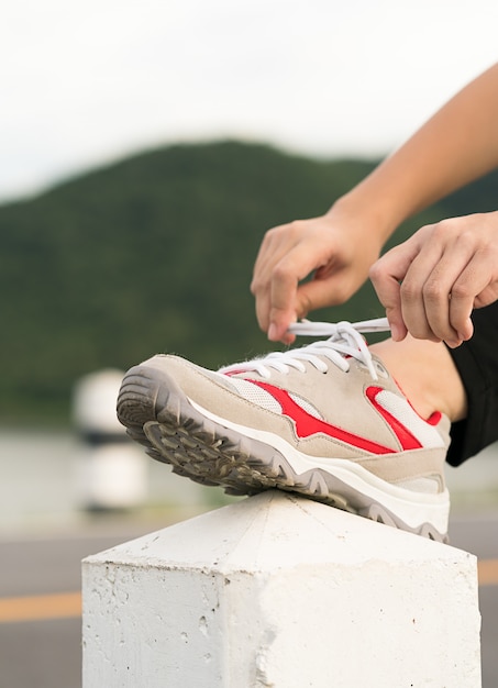 Mujer atar los cordones de los suyos antes de comenzar a correr