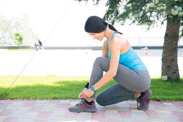 Mujer, atar, ella, shoelace, aire libre