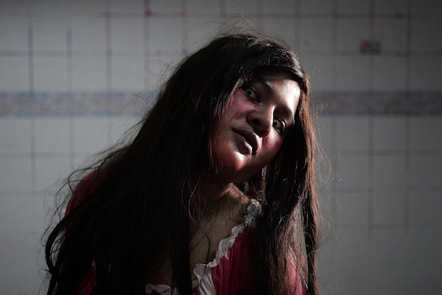 Mujer aterradora en vestido blanco con mancha de sangre después de asesinato concepto de Halloween