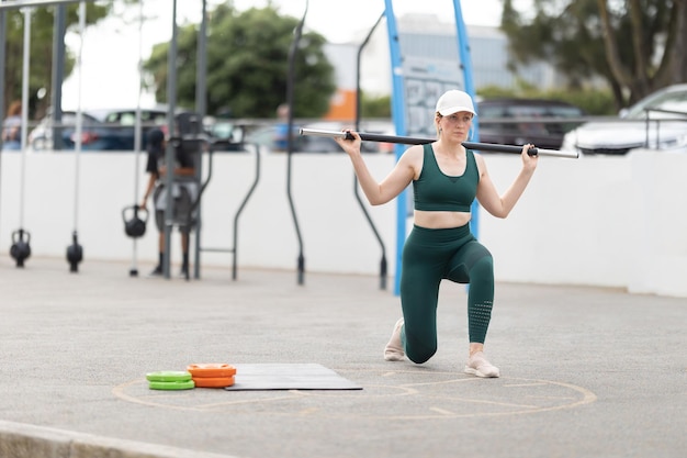 Mujer atlética adulta levantando una barra sobre sus hombros