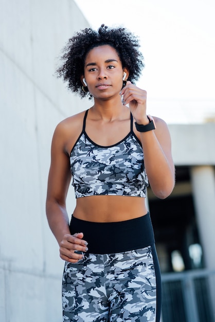 Mujer atlética afro corriendo y haciendo ejercicio al aire libre. Deporte y estilo de vida saludable.