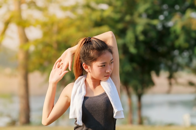 Mujer atlética asia calentando y atleta femenina joven sentada en un ejercicio y estiramiento en una