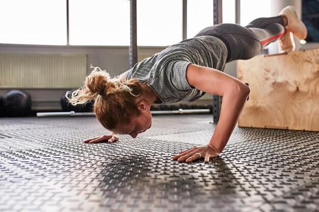 Mujer atlética atractiva exprimida en el gimnasio Concepto de entrenamiento proceso de entrenamiento deportivo