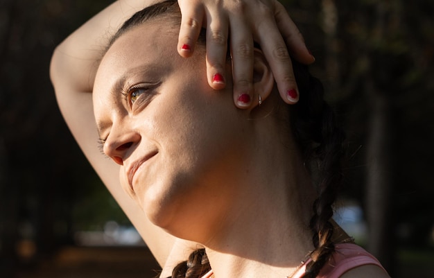 Mujer atlética haciendo ejercicios de estiramiento relajantes estirando el cuello antes de entrenar