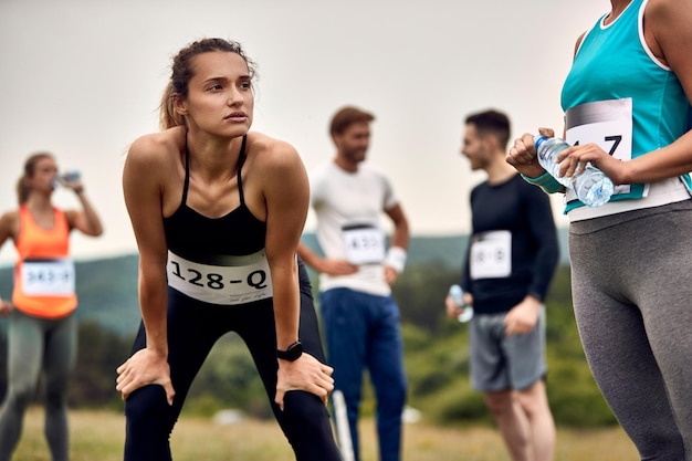 Mujer atlética joven que se relaja después de participar en un maratón en la naturaleza