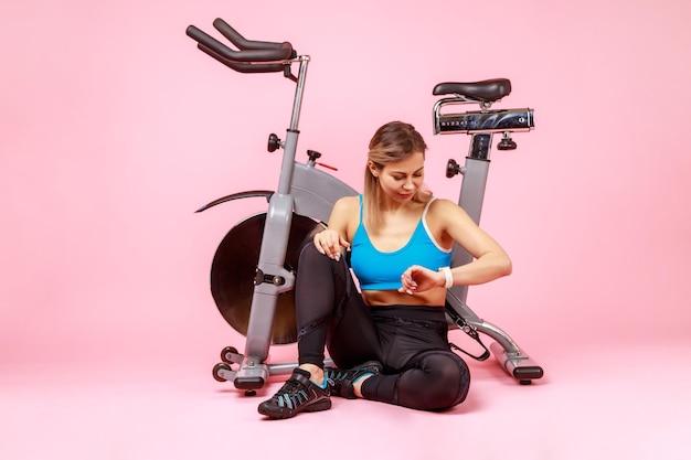 Mujer atlética mirando su rastreador de fitness comprobando los indicadores después del entrenamiento