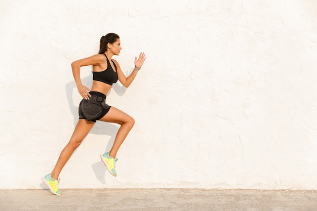 Foto mujer atlética en ropa deportiva trabajando y corriendo