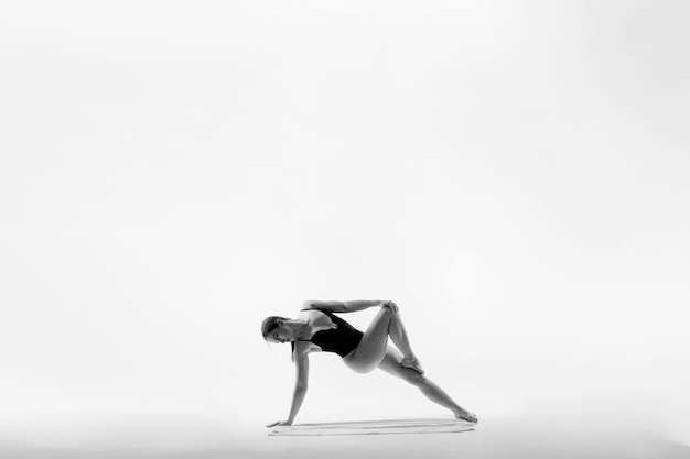 Mujer atlética en traje de baño haciendo flexiones de yoga hermosa mujer haciendo ejercicio en el estudio