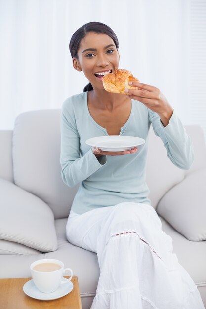 Mujer atractiva alegre desayunando