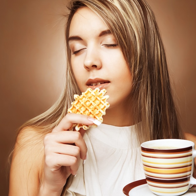 Mujer atractiva con café y galletas de cerca