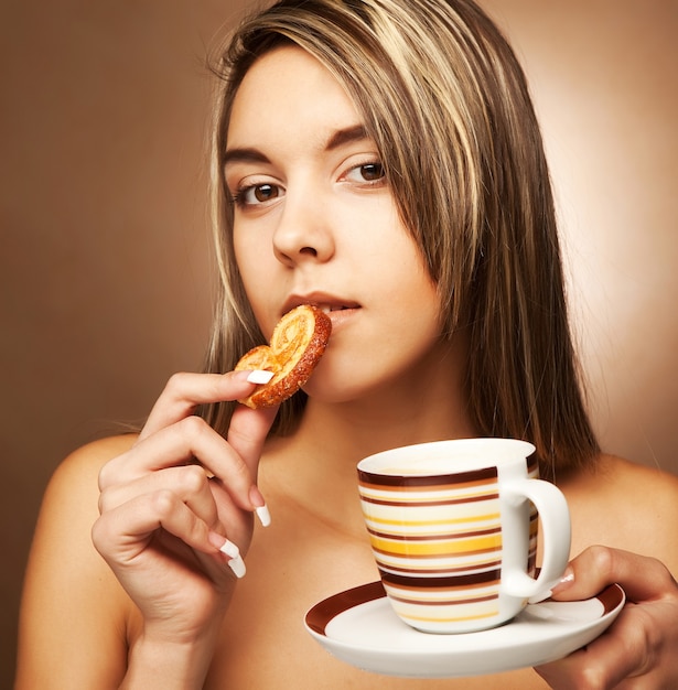 Mujer atractiva con café y galletas