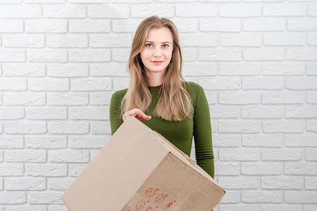Mujer atractiva con caja de paquetes entregando un paquete