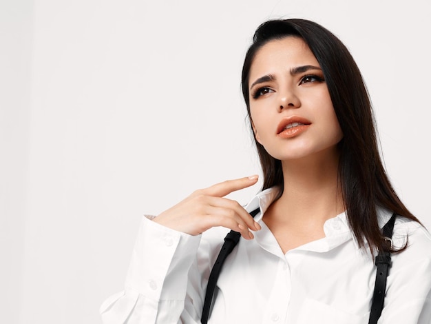 Mujer atractiva en una camisa con un cinturón sobre un fondo claro Espacio de copia