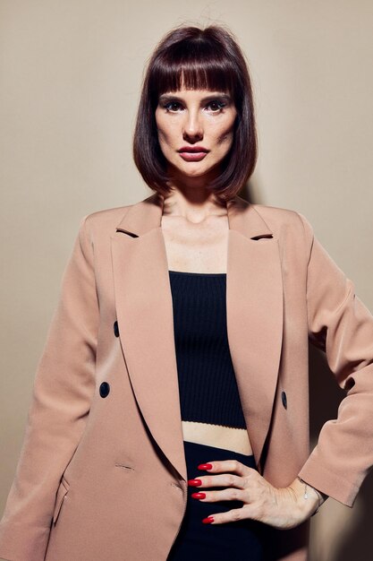 Mujer atractiva en una chaqueta beige estilo elegante posando fondo aislado